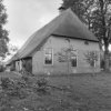 Achtergevel van rietgedekte boerderij, erfbeplanting