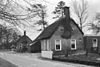 Kleine boerderij met woondeel met topgevel met vlechtingen en hoekschoorstenen