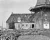 Zicht op de romp met een gedeelte van de stelling van de oliekorenmolen Woldzigt met het linkerdeel van de dienstgebouwen. - Roderwolde - 20188908 - RCE -  Woldzigt/ Oliekorenmolen 
