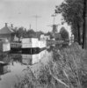 Dorpsgezicht met stellingmolen van voren gefotografeerd