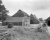 Rietgedekte boerderij met schuur, overzicht erf met landbouwwerktuig