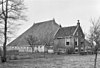 Kop-romp-boerderij met onderkelderd voorhuis met twaalfruitsvensters onder zadeldak tussen topgevels