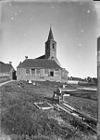Overzicht van de kerktoren vanuit het noodwesten gezien met woonhuis op de voorgrond - Anjum - 20022482 - RCE -  Nederlands Hervormde Kerk: Overzicht van de kerktoren vanuit het noodwesten gezien met woonhuis op de voorgrond 