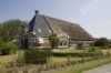 Overzicht van de voorgevel met de schuur rechts