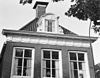 Pand met herbouwde voorgevel met rechte kroonlijst met triglieven en metopen onder zadeldak met voorschild, dakkapel en topschoorsteen