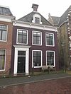 Eenvoudig pand met kroonlijst met consoles onder schilddak met dakkapel en twee schoorstenen