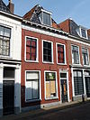 Pand met eenvoudige gevel, geblokte kroonlijst, zesruitsvensters op de verdieping en omlijste deur