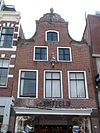 Pand met in de top rijk versierde klokgevel