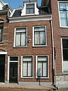 Eenvoudig pandje met verdieping en rechte kroonlijst waarboven dakkapel met houten klauwstukken