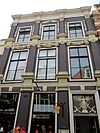 Pand met twee verdiepingen en met pilasters en festoenen versierde geval onder voor afgeschuind zadeldak