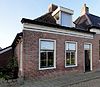 Eenvoudig pand onder zadeldak met voorschild waarboven topschoorsteen en met dakkapel met eenvoudige klauwstukken