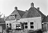 Tweelingpand met goot op klossen onder twee schilddaken, haaks op de rooilijn, beide met twee hoekschoorstenen
