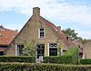 Pandje met zesruitsvensters en houten goot aan voorgevel onder aan de voorzijde afgewolfd zadeldak