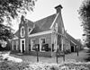 Overzicht voorgevel met halsgevel en rechter zijgevel, boerderij, thans dorpshuis - Bergum - 20345872 - RCE -  De Pleats: Overzicht voorgevel met halsgevel en rechter zijgevel, boerderij, thans dorpshuis (opmerking: Gefotografeerd voor Monumenten In Nederland Friesland, bladzijde 101) 