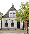 Laag pand onder voor afgeschuind hoog zadeldak met schoorsteen