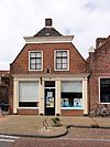 Pand onder zadeldak met voorschild waarboven topschoorsteen