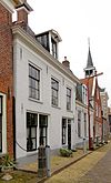Pand met verdieping onder hoog zadeldak met voorschild met schoorsteen met bord