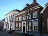 Markt 12: Boerderij met wolfdak, deuromlijsting van pilasters met hoofdgestel en stoep