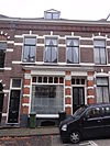 Woonblokje, bestaande uit één benedenwoning met winkel en twee bovenwoningen