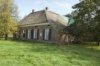 Voorgevel boerderij met gedeelte van de rechter zijgevel, gezien vanaf het weiland