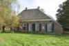 Voorgevel boerderij, boven elk schuifraam bevindt zicht een laag zoldervenster