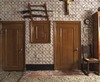Interieur, zicht op de wand met de ingebouwde broodkast tussen de gehoute deuren naar de kelder en de melkkamer, keitjesvloer op voorgrond