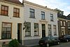 Buren - Rodenheldenstraat 7 - Woonhuis.JPG -  Gepleisterd pand met verdieping en lijstgevel uit het derde kwart van de 19e eeuw. Deuromlijsting met gesneden consoles, die een hoofdgestel dragen. 