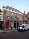 Deftig herenhuis onder dwars schilddak met dakvensters en hoekschoorstenen