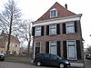 Huis met hoog schilddak, dat aan de achterzijde aansluit tegen een gotische puntgevel