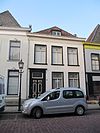 Pand met eenvoudige, geverfde gevel onder rechte lijst