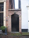 Huis van parterre en verdieping met hoog zadeldak tussen puntgevels met vlechtingen