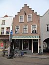 Pand met trapgevel waarvan de trapafdekkingen gewijzigd zijn en de zoldervensters een roedenverdeling in 18e-eeuwse stijl hebben