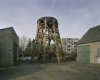 Houten constructie van molenromp met daarnaast een schuur