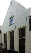Huis met gepleisterd puntgeveltje, parterre met zolderverdieping