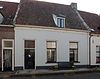 Woonhuis onder hoog zadeldak waarin dakvenster en gepleisterde gevel onder rechte lijst