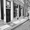 Huis met gepleisterde klokgevel met zijvoluten en segmentvormige bekroning