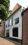 Boerderij met schilddak en gepleisterde gevel onder rechte lijst