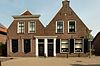 Pand onder zadeldak met aan de voorzijde een puntgevel met vlechtingen en tuitvormige bekroning met licht gebogen afdekking