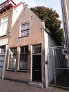 Pand met eenvoudige puntgevel met vlechtingen en vorkankers. Zes- en vierruitsschuiframen