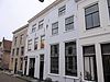 Kerkstraat 18 - Pand met verdieping en schilddak, 17e eeuw. Gepleisterde gevel onder rechte kroonlijst. Twee sierankers 