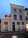 Waterstraat 44 - Huis uit de 16e of 17e eeuw, dat in het derde kwart der 19e eeuw een gepleisterde lijstgevel met vijf consoles onder de kroonlijst verkreeg. Stoep met hardstenen palen, waartussen kettingen. 