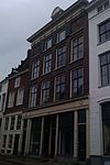 Pand met statige lijstgevel met rijk gesneden kroonlijst, gedragen door consoles