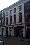Pand met gepleisterde lijstgevel met stucversieringen