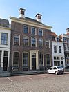 Deftig patriciershuis met lijstgevel en omlopend schilddak met hoekschoorstenen