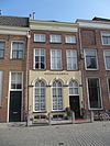 Pand met rood gesausde lijstgevel met in de verdieping en zolderverdieping schuiframen