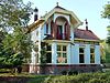 Spijk - Hoofdweg-Noord 27 (1) -  Rentenierswoning in Overgangsstijl met Art Nouveau-elementen met aangebouwd koetshuis aan de Hoofdweg-Noord 27 in het Groningse dorp Spijk.