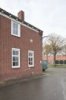 Overzicht van rechterdeel voorgevel, gelbeÃ«indiging bovenkant met uikragend metselwerk en gootklossen, buitenlantaarn en gevelsteen