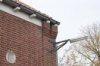 Detail van rechterdeel voorgevel, gevelbeÃ«indiging bovenkant met uikragend metselwerk en gootklossen, buitenlantaarn en gevelsteen