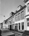 Voorgevels - Groningen - 20093880 - RCE -  De Hardewikerstraat in Groningen, 1976. Links van het midden Hardewikerstraat 23 (met uithangbord, rm 18490), rechts daarvan Hardewikerstraat 21 (rm 18489). 