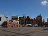 Drie gezusters Groningen -  De Grote Markt in Groningen, 2012, met v.l.n.r. een tijdelijke constructie voor het zicht op de bouw van het Groninger Forum, de panden Grote Markt 36 (achter de lichtmast, Hotel de Doelen, dubbelpand, rm 18468/18469), 37 (rm 18470), 38 (rm 18471) en het hoekpand Grote Markt 39/Gelkingstraat 2-4 (rm 18472). 